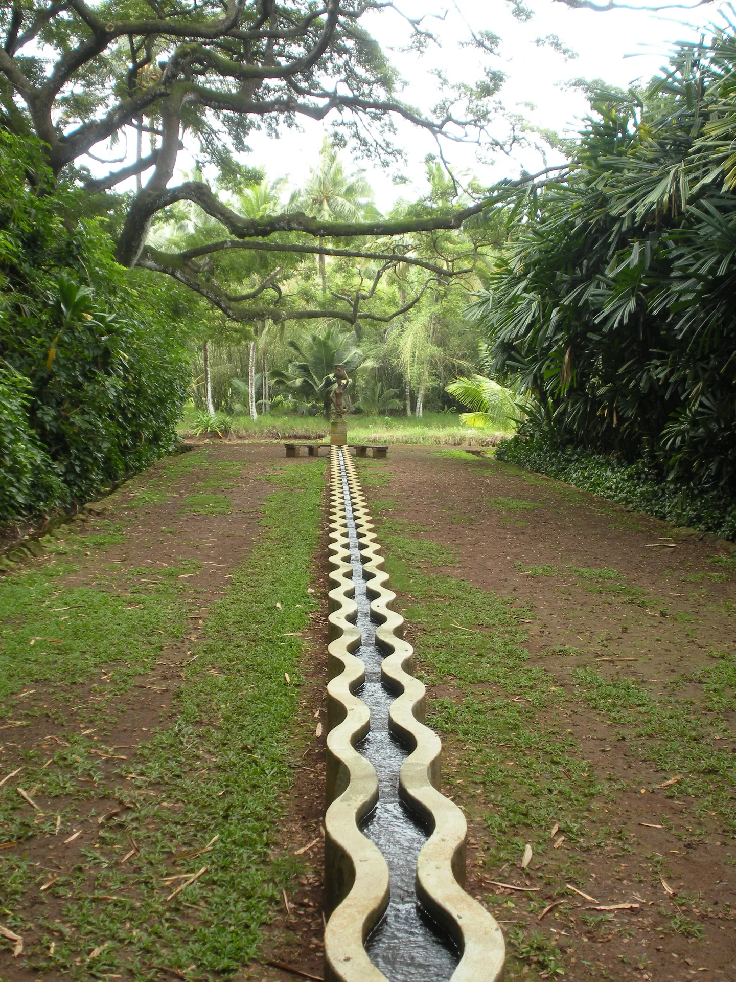A structured garden path leading to a central point, representing self-service SaaS onboarding designed to guide new customers to time to value without a person walking beside them.