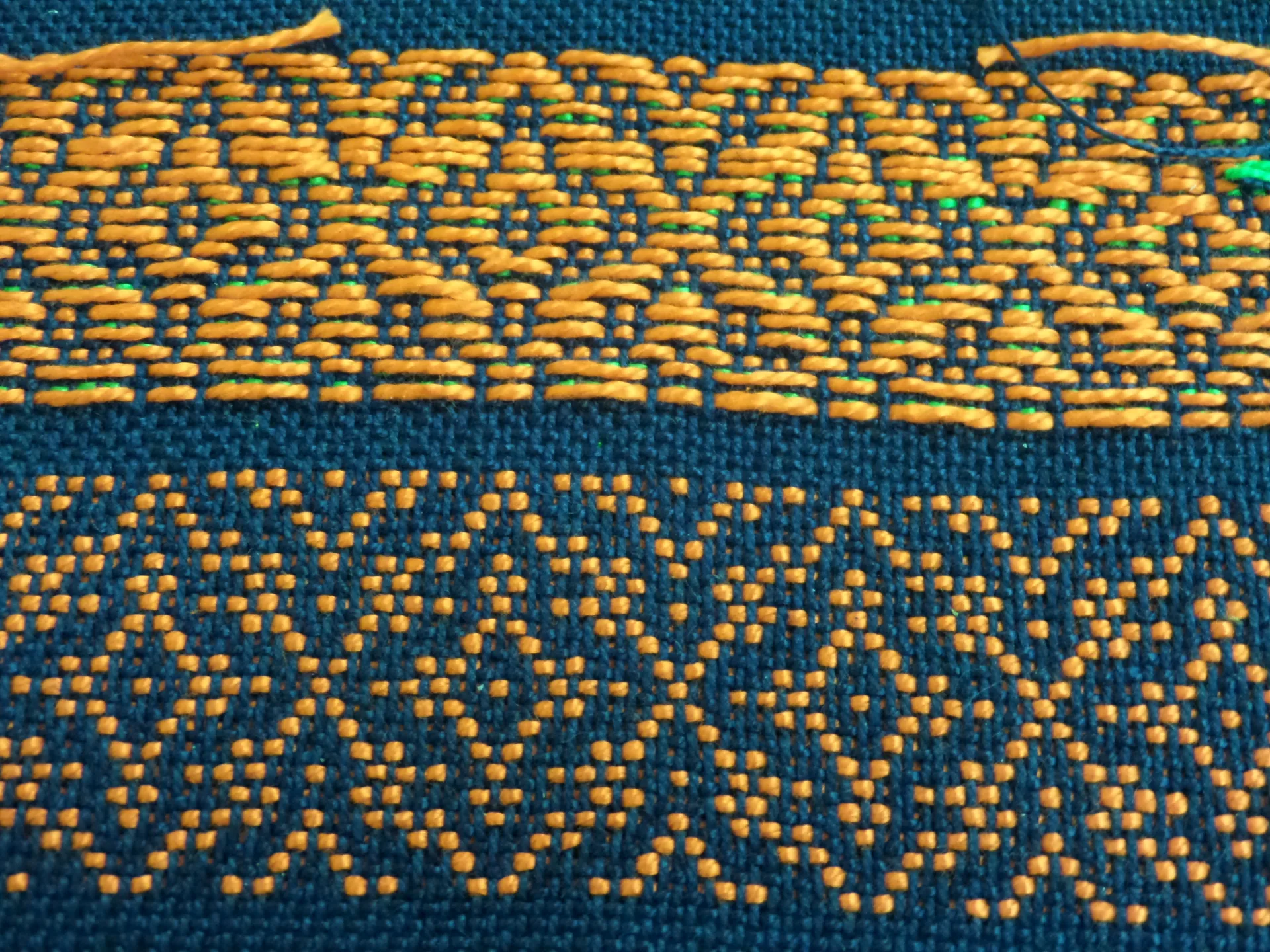Close-up of interlaced gold and blue threads in a woven textile, representing the two interwoven value cases for user assistance content.